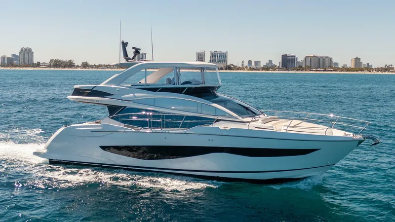 Slide: The Image of 2023 Pearl 62 yacht cruising on blue ocean near city skyline. - 1