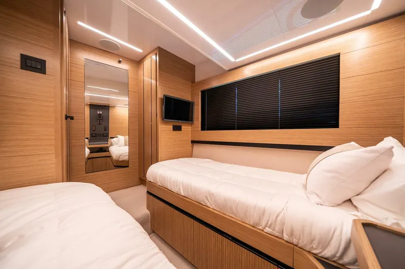 Slide: The Image of Luxurious cabin interior of 2023 Pearl 62 yacht with modern wood finish and twin beds. - 29