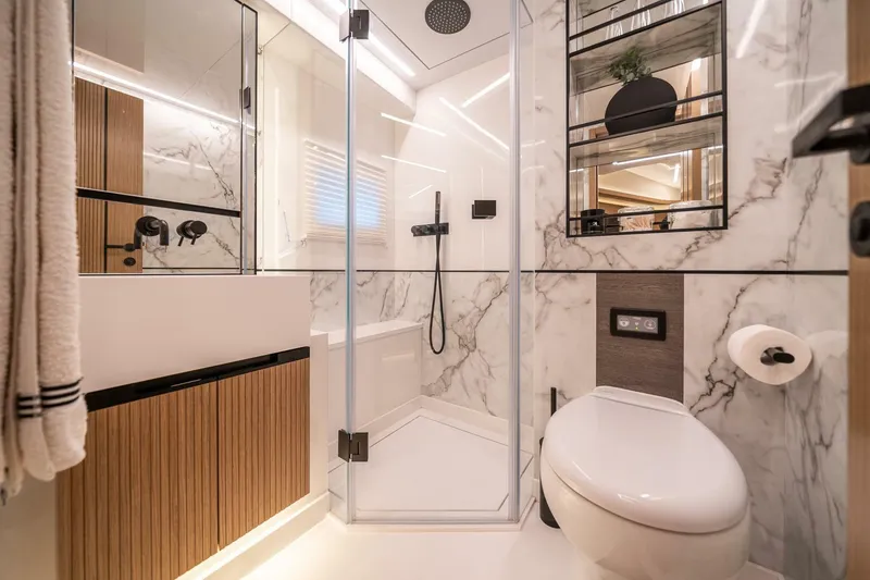 Slide: The Image of Modern bathroom with marble walls, glass shower, and sleek fixtures in a 2023 Pearl 62 model. - 34