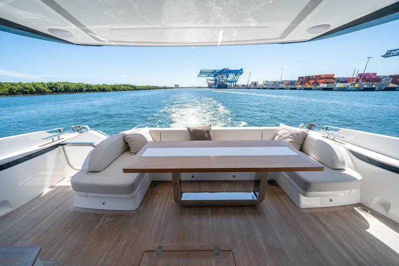 Slide: The Image of Luxury Pearl 62 yacht deck with seating and table, cruising on a sunny day, 2023 model. - 47