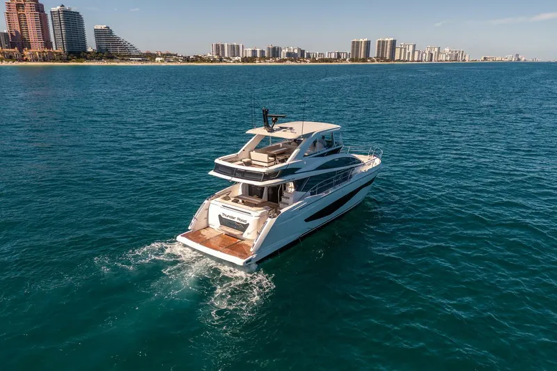 Slide: The Image of Luxurious 2023 Pearl 62 yacht cruising on clear blue ocean near city skyline. - 5