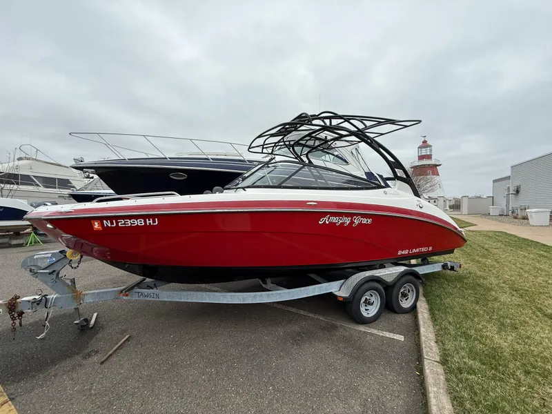Slide: The Image of 2016 Yamaha Boats 242 Limited S E-Series, red, on trailer near marina. - 22