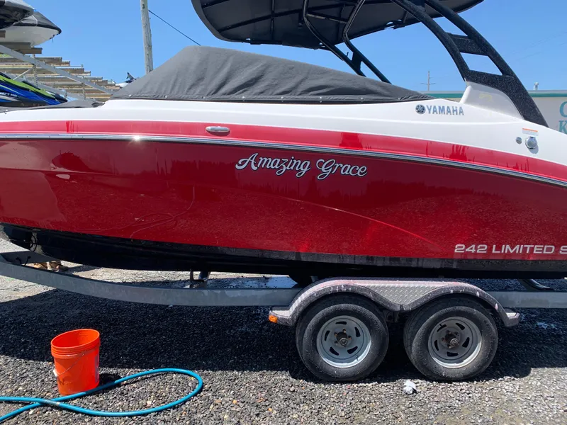 Slide: The Image of 2016 Yamaha 242 Limited S E-Series boat on trailer, red hull, "Amazing Grace" text visible. - 9