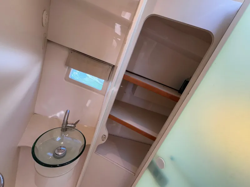 Slide: The Image of 2015 Pursuit SC 365i Sport Coupe bathroom with glass sink and storage shelves. - 20