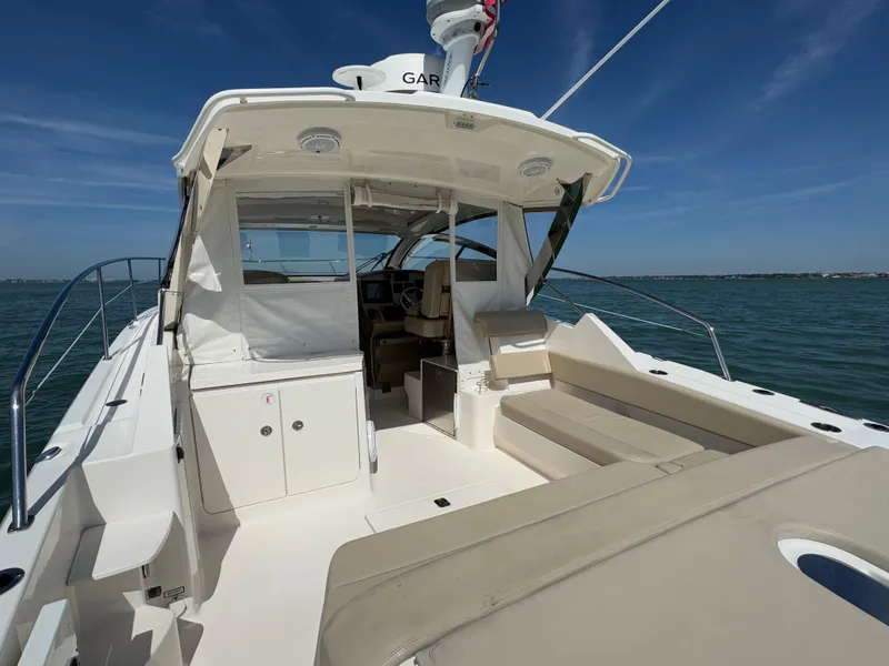 Slide: The Image of 2015 Pursuit SC 365i Sport Coupe on water, featuring spacious deck and seating area. - 25