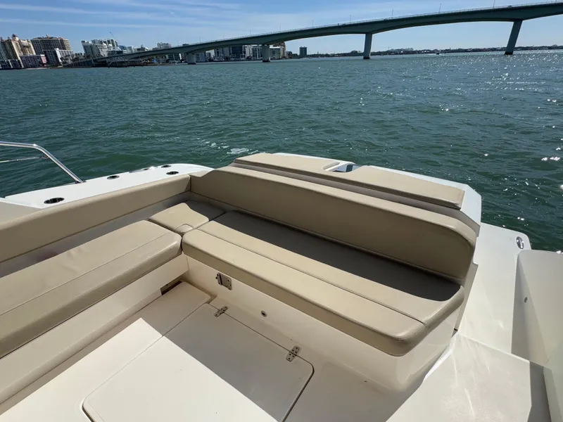 Slide: The Image of 2015 Pursuit SC 365i Sport Coupe with beige seating, overlooking a scenic waterfront and bridge. - 26