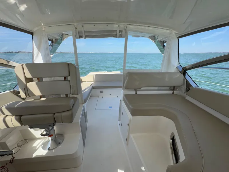 Slide: The Image of 2015 Pursuit SC 365i Sport Coupe interior with ocean view, featuring seating and helm area. - 28