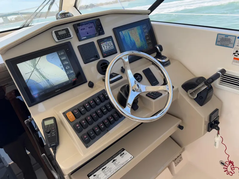Slide: The Image of Control panel of 2015 Pursuit SC 365i Sport Coupe with navigation screens and steering wheel. - 32