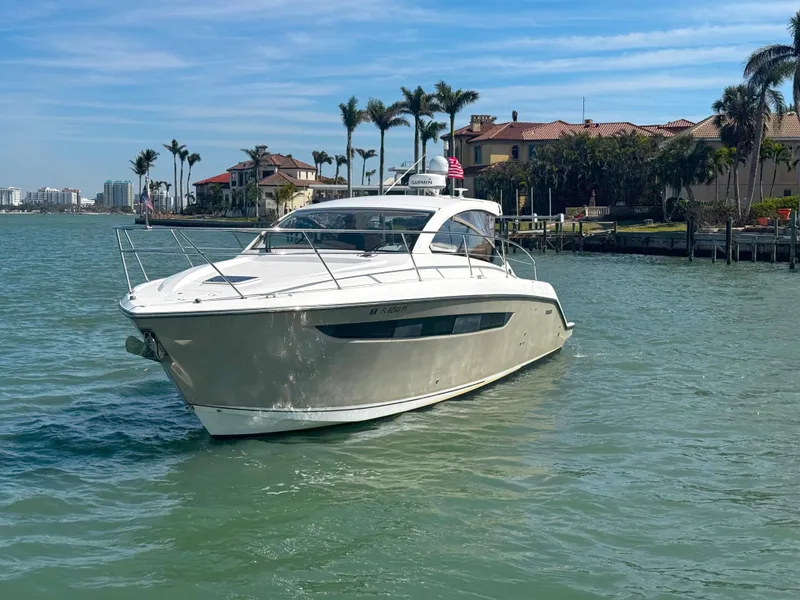 Slide: The Image of 2015 Pursuit SC 365i Sport Coupe cruising near waterfront homes. - 6