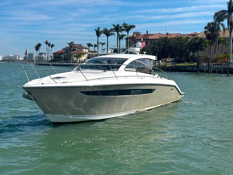 Slide: The Image of 2015 Pursuit SC 365i Sport Coupe yacht cruising near waterfront homes. - 7