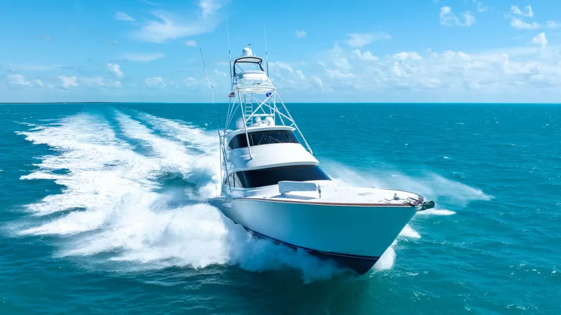 Slide: The Image of 2019 Viking 72 Enclosed Bridge yacht cruising on open ocean under clear blue sky. - 12