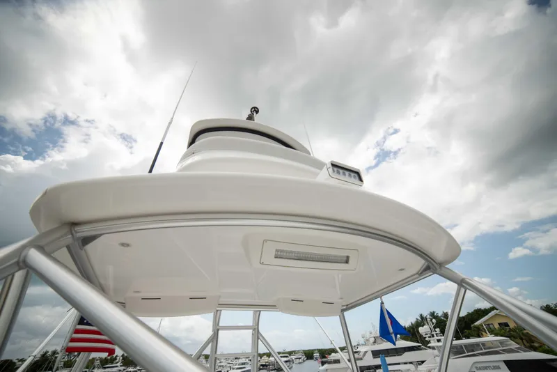 Slide: The Image of 2019 Viking 72 Enclosed Bridge yacht, view of upper deck and radar, cloudy sky background. - 32