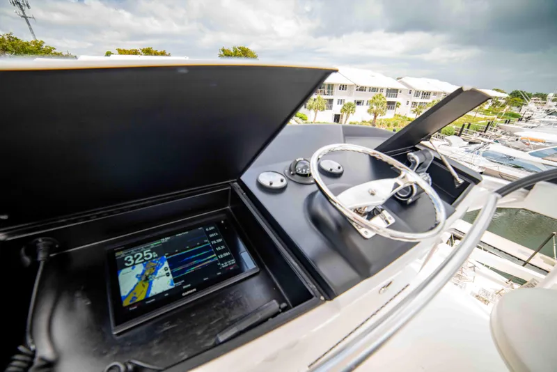 Slide: The Image of 2019 Viking 72 Enclosed Bridge yacht helm with navigation display and steering wheel. - 33