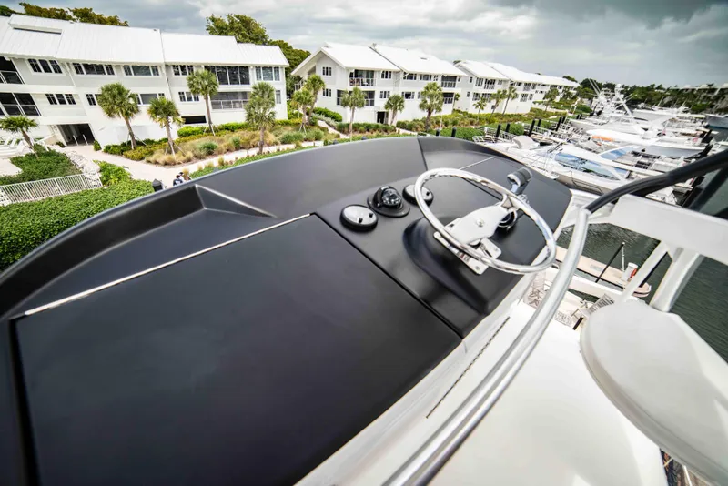 Slide: The Image of 2019 Viking 72 Enclosed Bridge yacht helm with marina and waterfront view. - 34