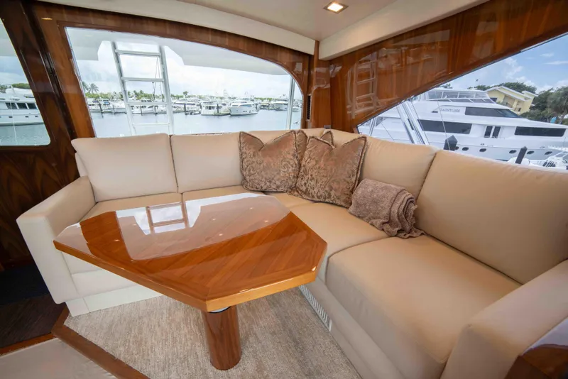 Slide: The Image of Luxurious interior of 2019 Viking 72 Enclosed Bridge yacht with plush seating and wooden table. - 41