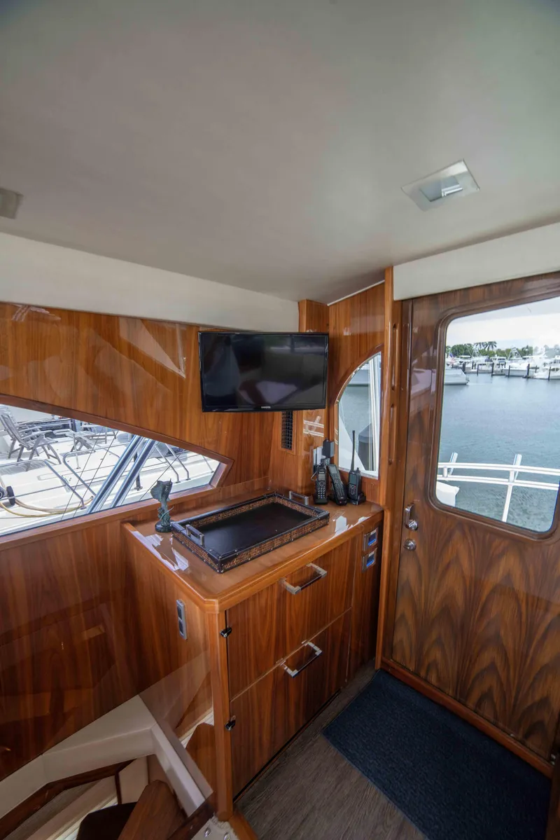 Slide: The Image of Interior of 2019 Viking 72 Enclosed Bridge yacht with wood paneling and modern amenities. - 44