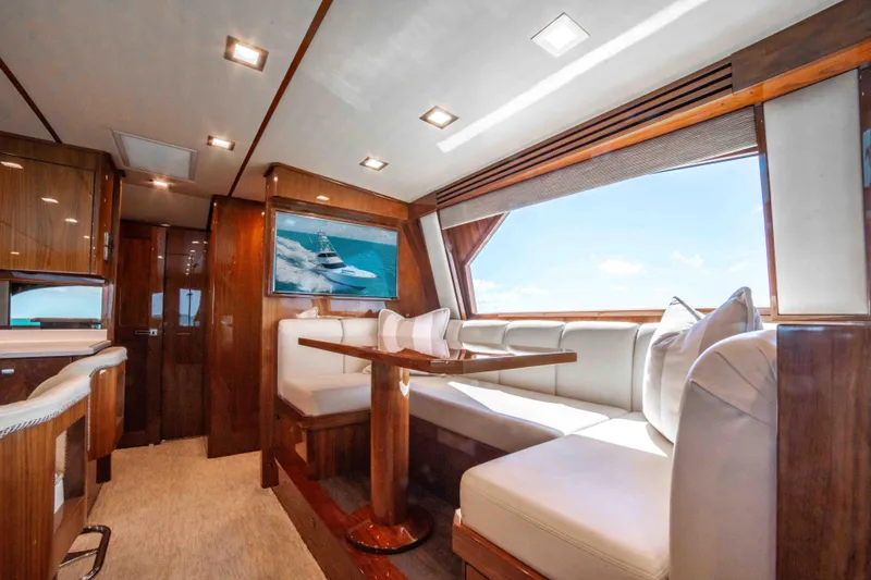 Slide: The Image of Luxurious interior of 2019 Viking 72 Enclosed Bridge yacht with elegant seating and large windows. - 48