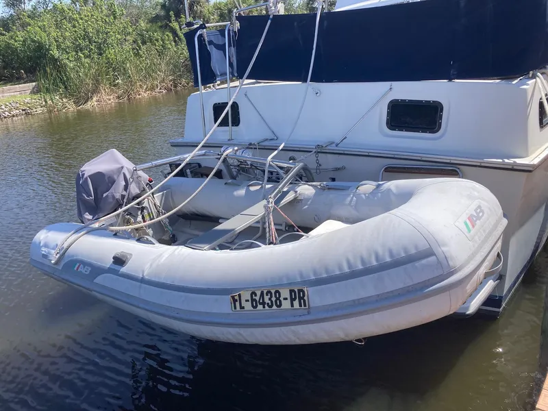 Slide: The Image of 1984 Mainship 40 DC Sundeck with inflatable dinghy attached at the stern. - 7
