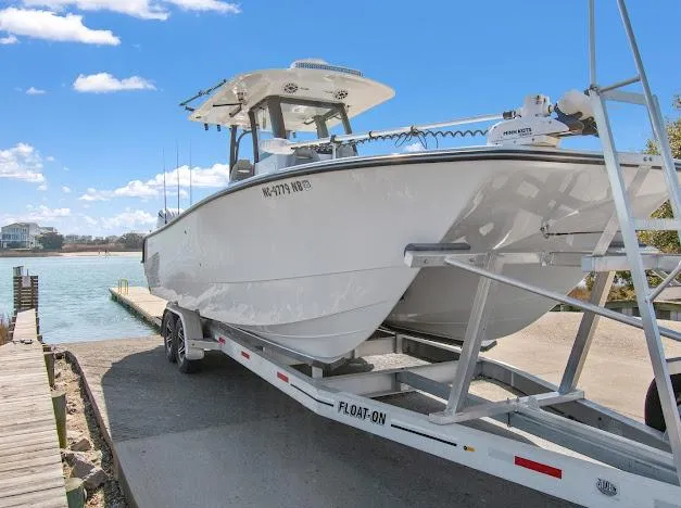 Slide: The Image of 2024 Freeman 28 boat on trailer at boat ramp under clear blue sky. - 12