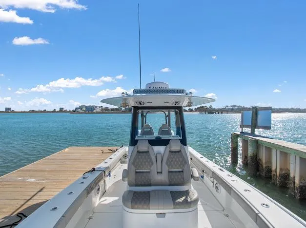 Slide: The Image of 2024 Freeman 28 boat docked by serene blue waters under a clear sky. - 19
