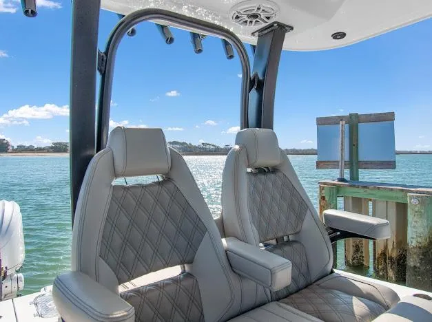 Slide: The Image of Luxury seating on a 2024 Freeman 28 boat, overlooking a serene water view. - 20