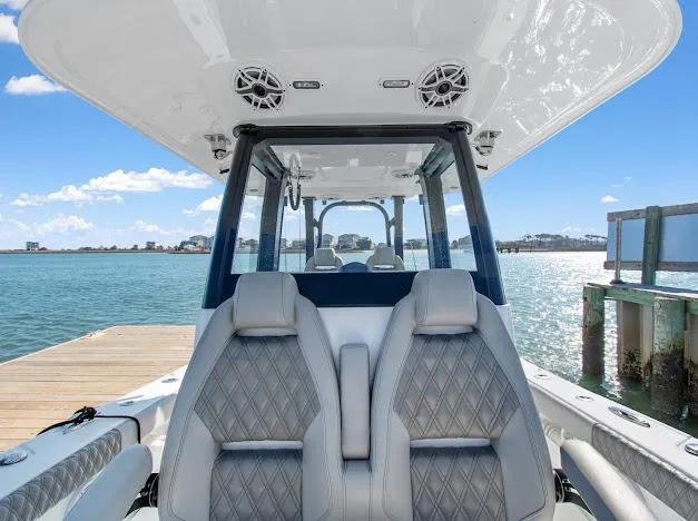 Slide: The Image of 2024 Freeman 28 boat interior with luxurious seating, docked by serene waters. - 23