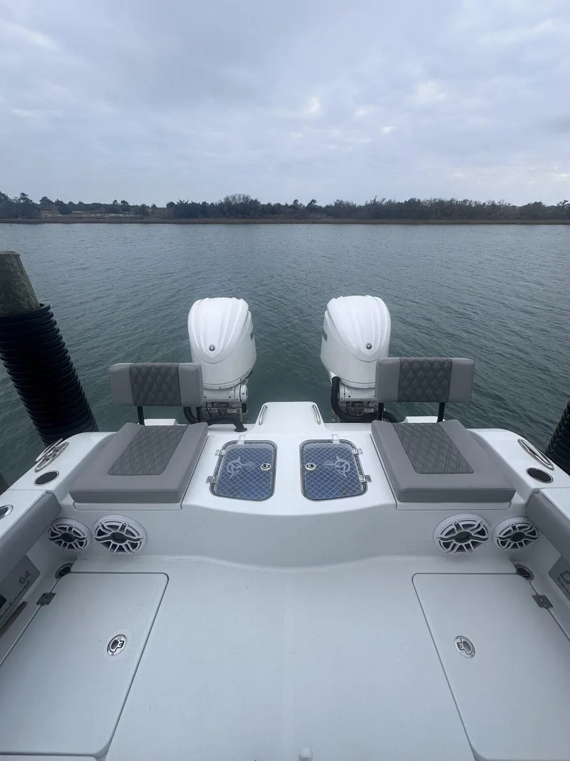 Slide: The Image of 2024 Freeman 28 boat with dual engines on a calm water backdrop. - 24