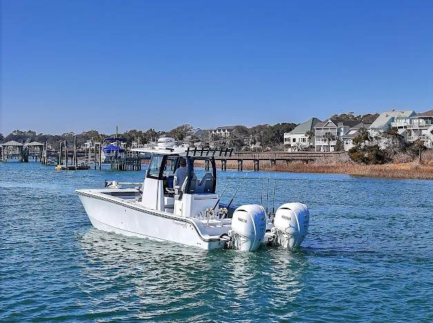 Slide: The Image of 2024 Freeman 28 boat on calm water near coastal homes. - 3