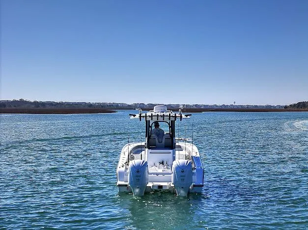 Slide: The Image of 2024 Freeman 28 boat cruising on a clear blue waterway under a bright sky. - 5