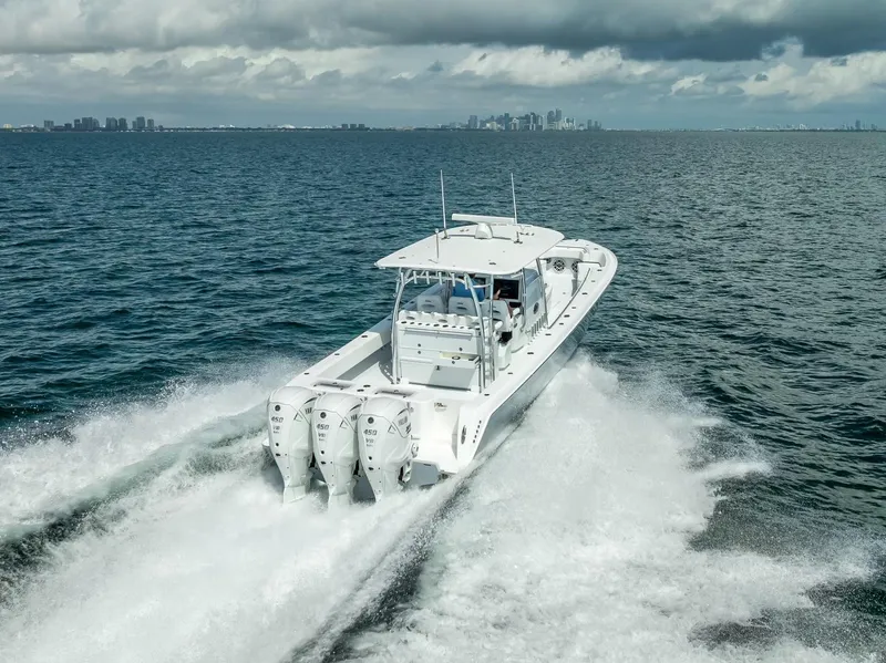 Slide: The Image of 2025 Contender 44 ST boat cruising on open water with city skyline in background. - 13