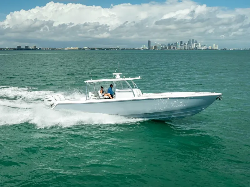 Slide: The Image of 2025 Contender 44 ST boat cruising on open water with city skyline in background. - 17