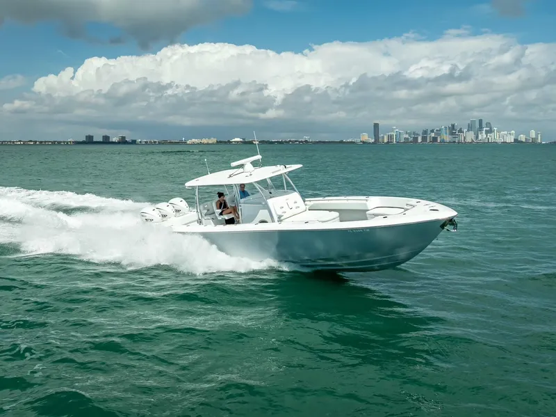 Slide: The Image of 2025 Contender 44 ST boat cruising on open water with city skyline in background. - 19