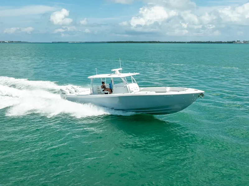 Slide: The Image of 2025 Contender 44 ST boat cruising on turquoise ocean waters under a clear sky. - 20