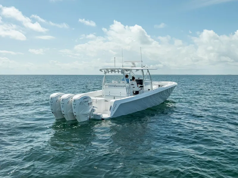 Slide: The Image of 2025 Contender 44 ST boat with triple engines on open water under a clear sky. - 23
