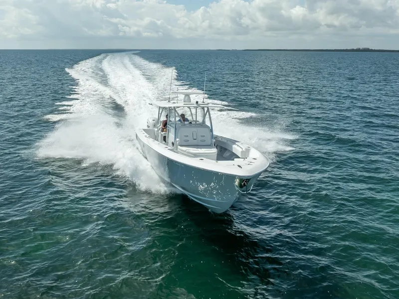 Slide: The Image of 2025 Contender 44 ST boat cruising on open ocean under cloudy sky. - 30
