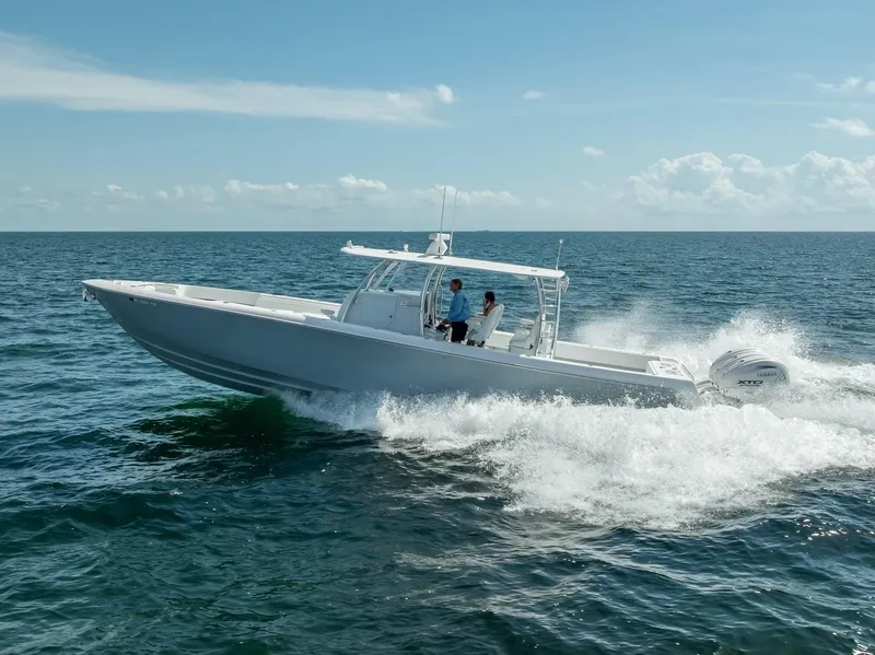 Slide: The Image of 2025 Contender 44 ST boat cruising on open sea under clear blue sky. - 34