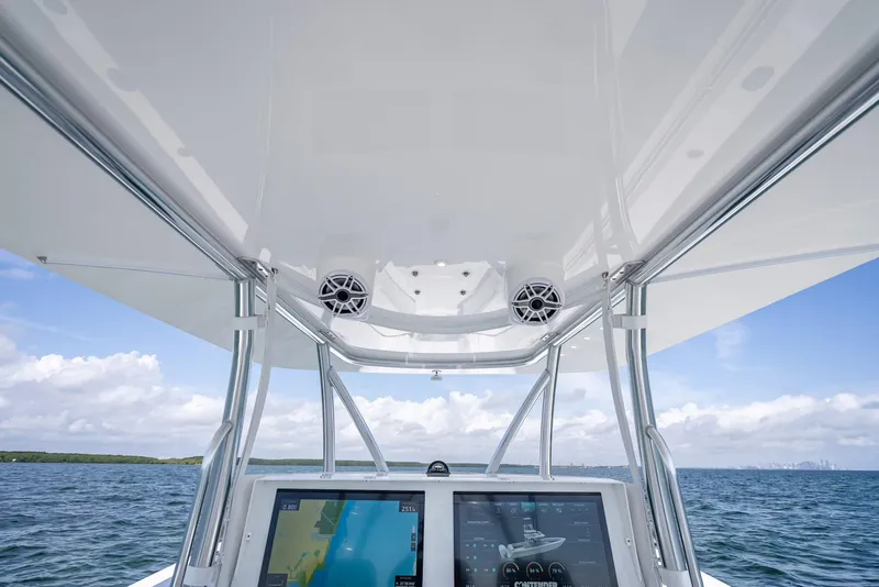 Slide: The Image of 2025 Contender 44 ST boat helm with dual screens, ocean view, and overhead speakers. - 38