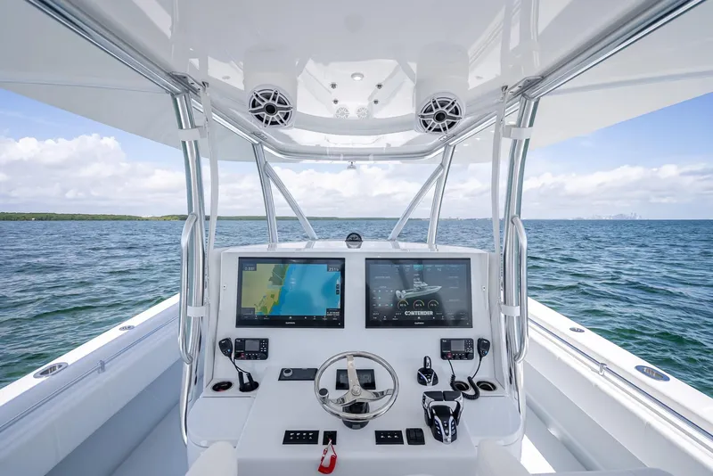 Slide: The Image of 2025 Contender 44 ST boat cockpit with advanced navigation systems on open water. - 41