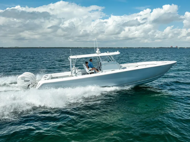 Slide: The Image of 2025 Contender 44 ST boat cruising on open water under a partly cloudy sky. - 9