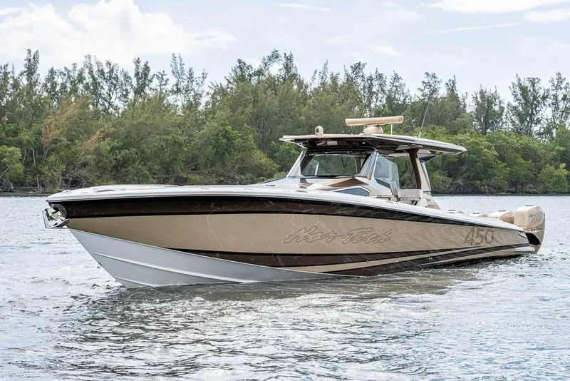 Slide: The Image of 2019 Nor-Tech 450 Sport Center Console boat on water, surrounded by trees. - 3