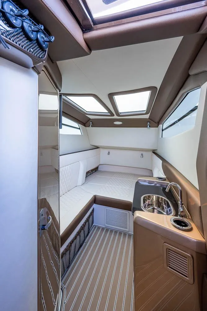 Slide: The Image of Interior of 2019 Nor-Tech 450 Sport Center Console, featuring a cozy cabin and kitchenette. - 31