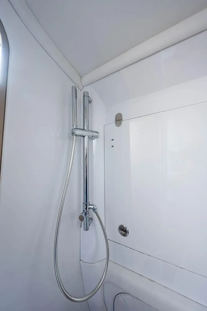 Slide: The Image of Shower area in 2019 Nor-Tech 450 Sport Center Console boat, featuring sleek chrome fixtures. - 33