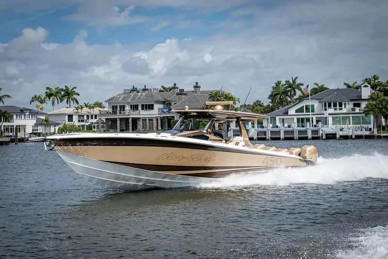 Slide: The Image of 2019 Nor-Tech 450 Sport Center Console cruising on a scenic waterfront. - 36