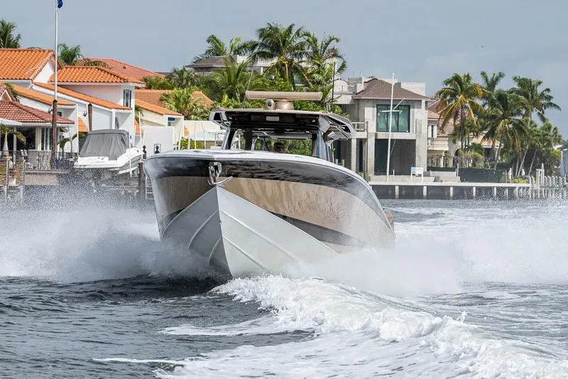 Slide: The Image of 2019 Nor-Tech 450 Sport Center Console cruising near waterfront homes. - 37