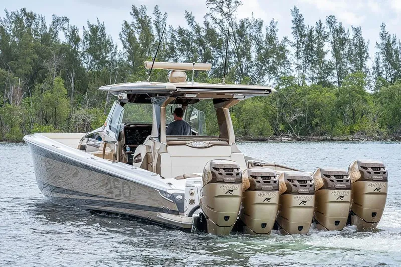 Slide: The Image of 2019 Nor-Tech 450 Sport Center Console boat with quad engines on a scenic waterway. - 4