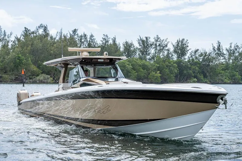 Slide: The Image of 2019 Nor-Tech 450 Sport Center Console boat cruising on a scenic waterway. - 40