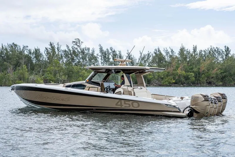 Slide: The Image of 2019 Nor-Tech 450 Sport Center Console boat on a calm lake with trees in the background. - 42