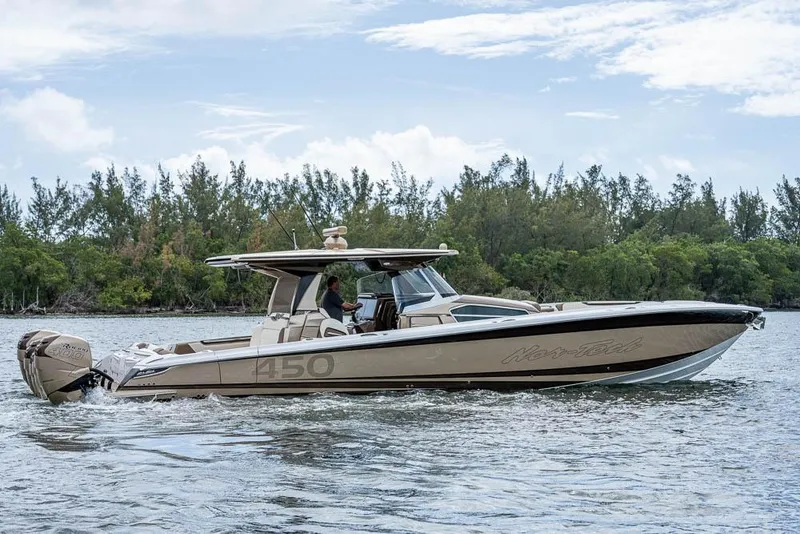 Slide: The Image of 2019 Nor-Tech 450 Sport Center Console boat cruising on a scenic waterway. - 45