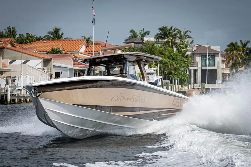 Slide: The Image of 2019 Nor-Tech 450 Sport Center Console cruising in a scenic waterfront setting. - 46