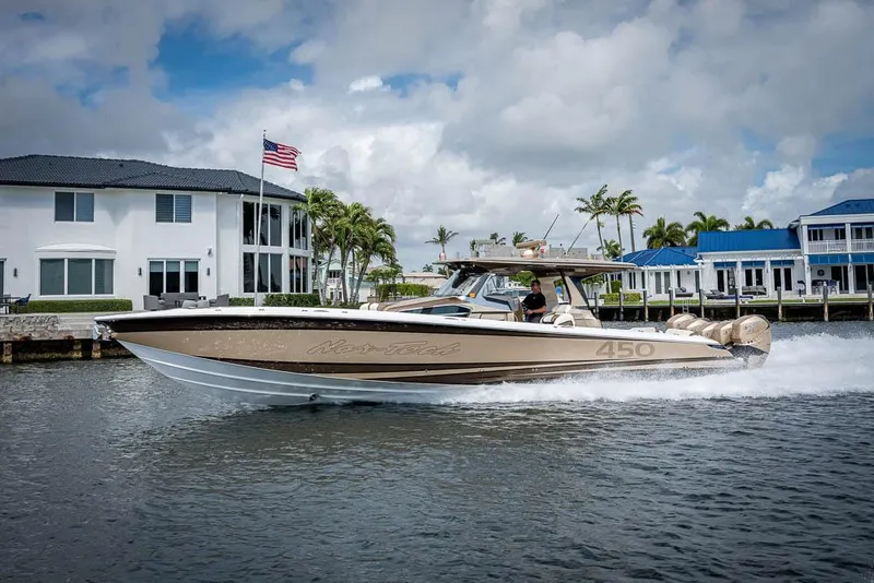 Slide: The Image of 2019 Nor-Tech 450 Sport Center Console cruising on a sunny day near waterfront homes. - 49